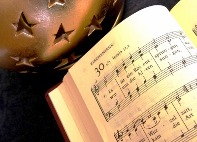 Weihnachtskugel neben aufgeschlagenem Gesangsbuch