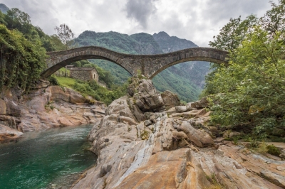 Brücke über Fluss in Berglandschaft (Schweiz)